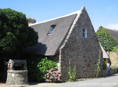 Photo d'un puits et d'une chaumière en Bretagne