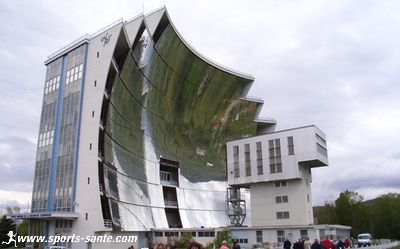 Photo de la grande parabole du four solaire et du foyer concentrateur d'énergie.