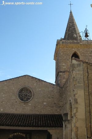 Photo de l'église et de son clocher en flèche de pierre à Puisserguier en Hérault