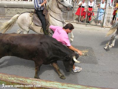 Photo d'un coureur et d'un taureau d'abrivado