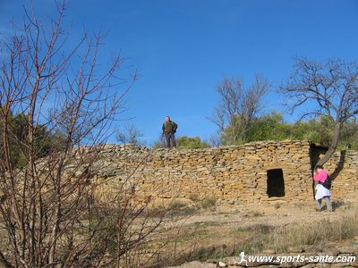 Photo d’un guetteur armé de son fusil perché sur une capitelle scrutant les environs, à l’affût du gibier